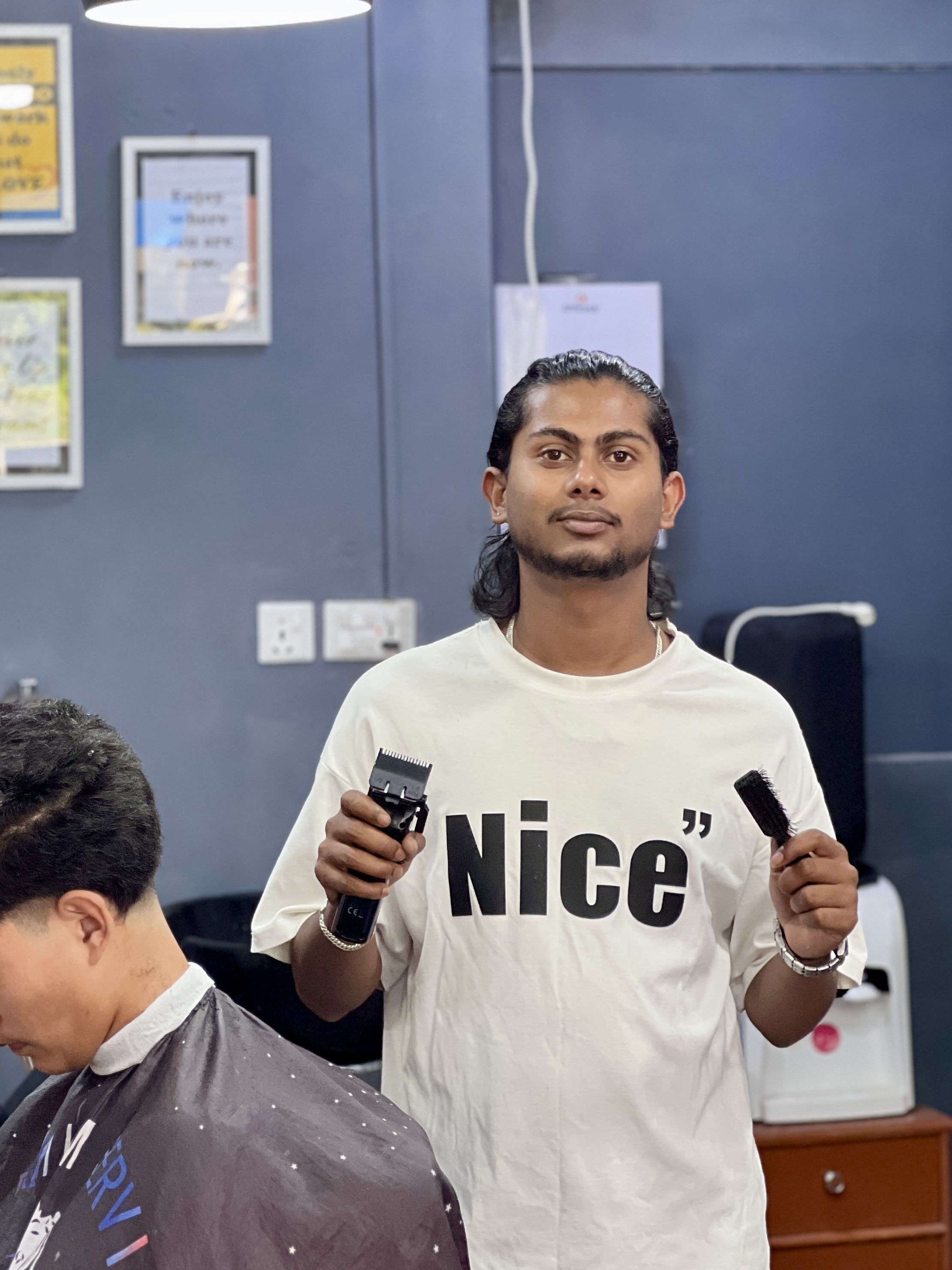 Portrait of Nabin Sharma holding barber clippers