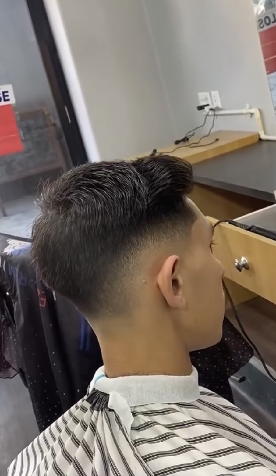 Side back view of a clean fade haircut with brushed top