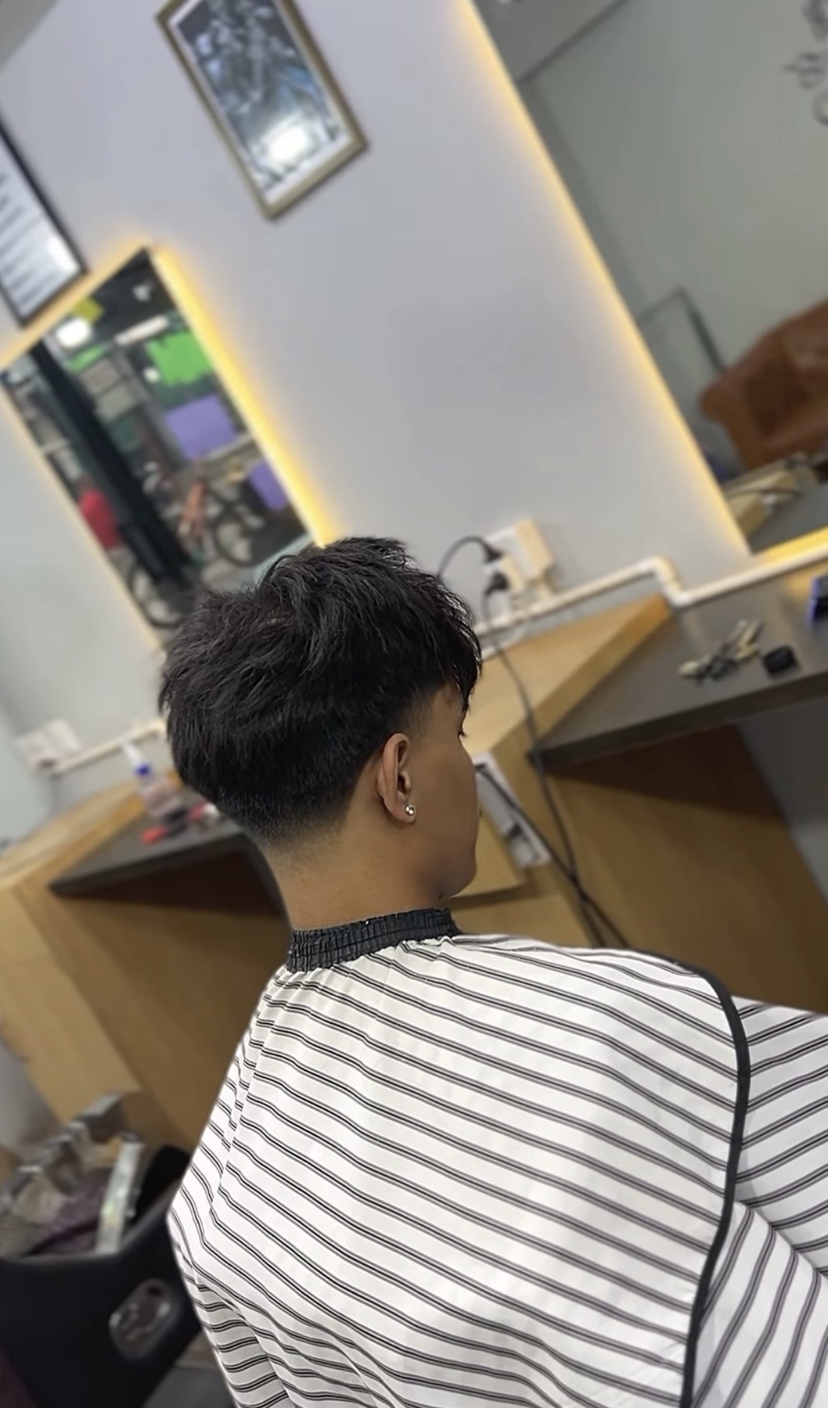 Back side view of a soft taper haircut with textured top