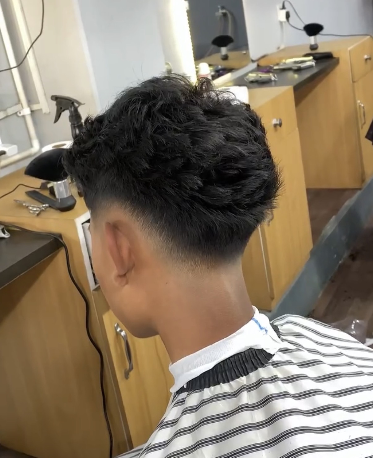 Side view of a curly drop fade haircut
