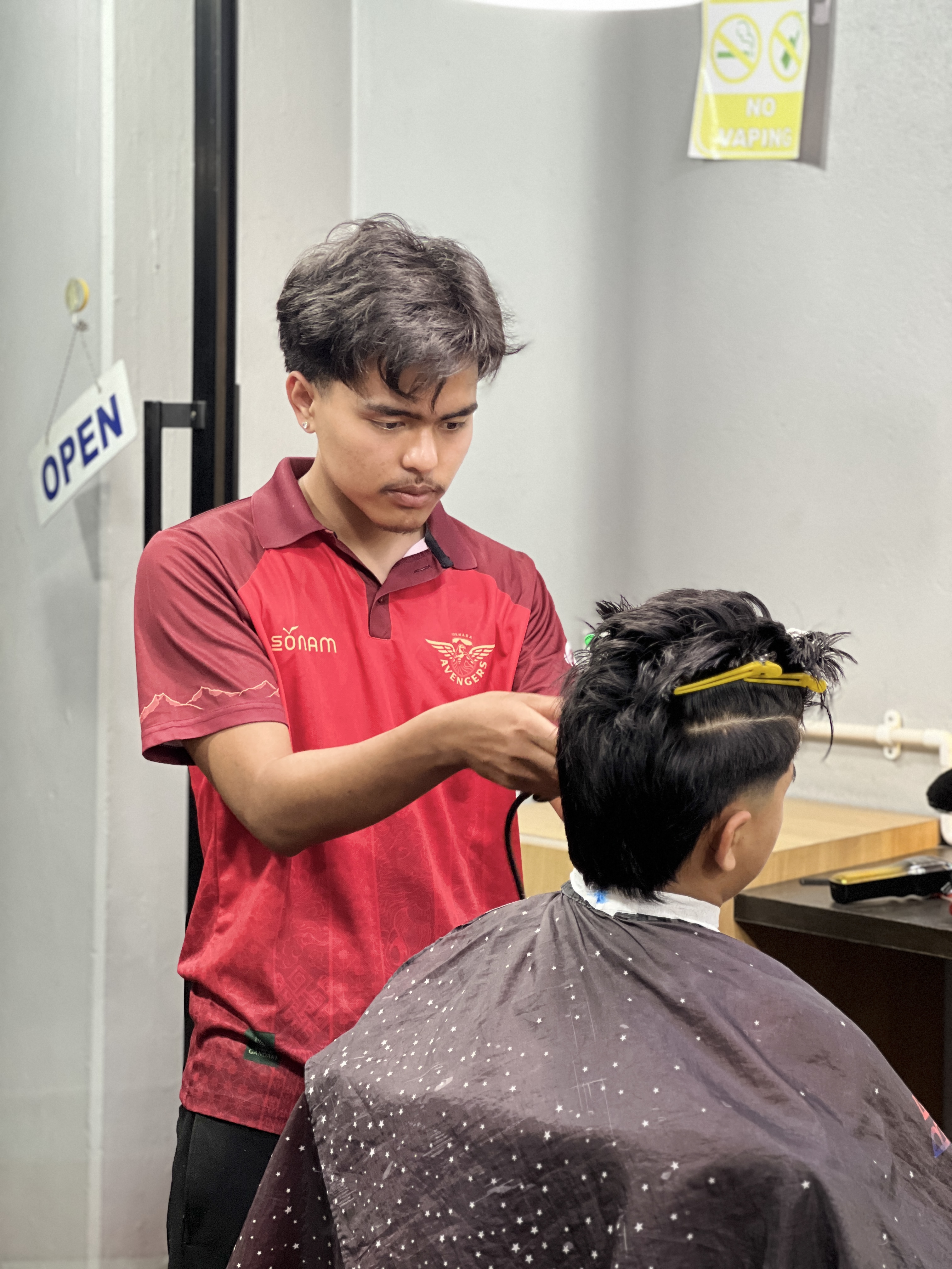 Portrait of Sergam Tamang holding barber clippers